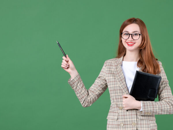 female-teacher-holding-notepad-green